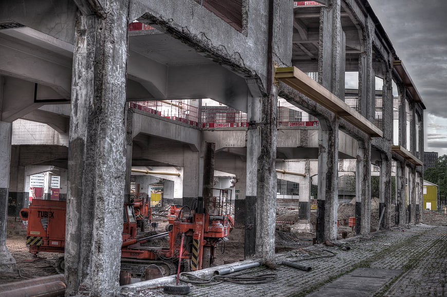 HDR Construction Site with Concrete Pillars and Orange Machinery