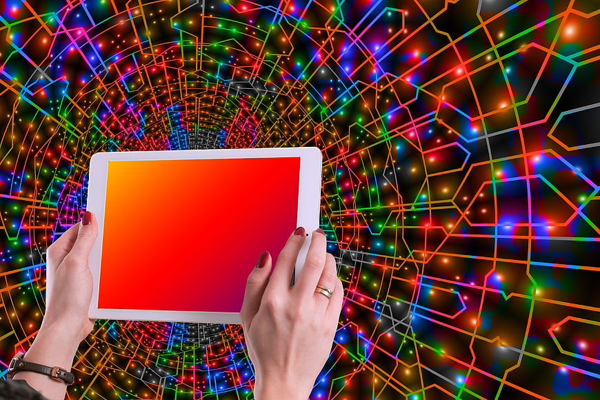 Hands holding tablet with colorful digital network background