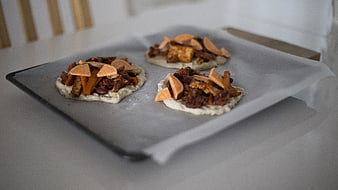 Unbaked mini pizzas with sweet potato and beans on baking sheet