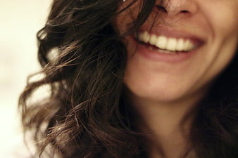 Close-up of a woman laughing with hair covering face