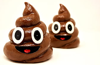 Two glossy brown ceramic poop emoji figurines with cartoon faces