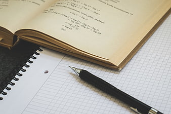 Open Mathematics Textbook with Pen on Grid Paper