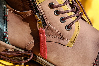 Close-up of brown leather boot with zipper and laces