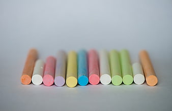 Row of colorful chalk sticks on a light gray background