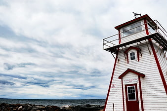 White and Red Arisaig Lighthouse on Rocky Coast