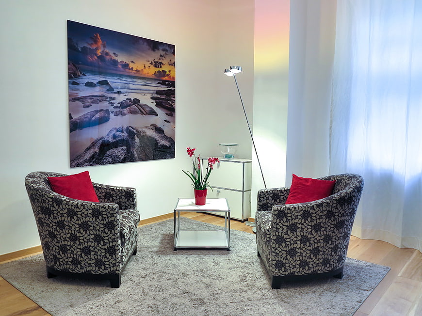 Modern Therapy Room Interior With Patterned Armchairs And Red Cushions
