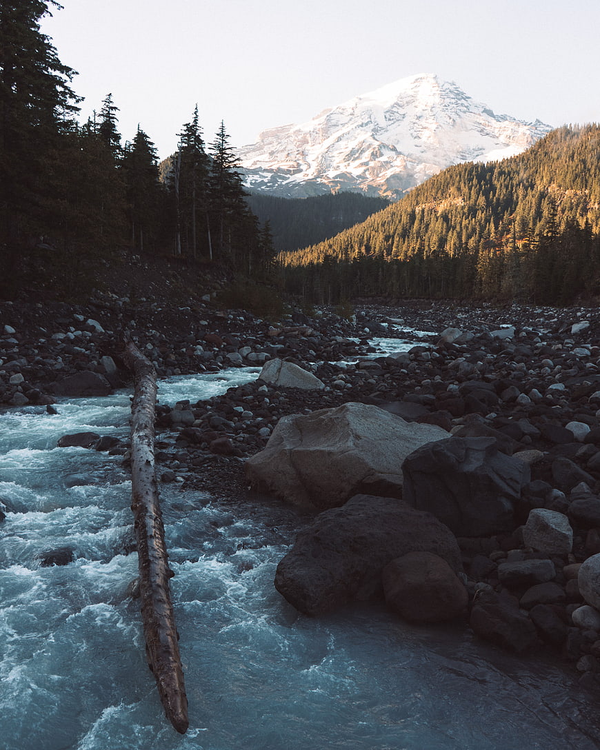 Snow-Capped Mountain Peak Over Rocky River Valley