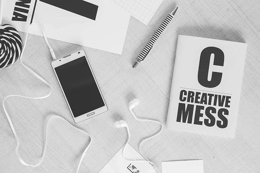 Flat lay of smartphone, headphones, and creative workspace