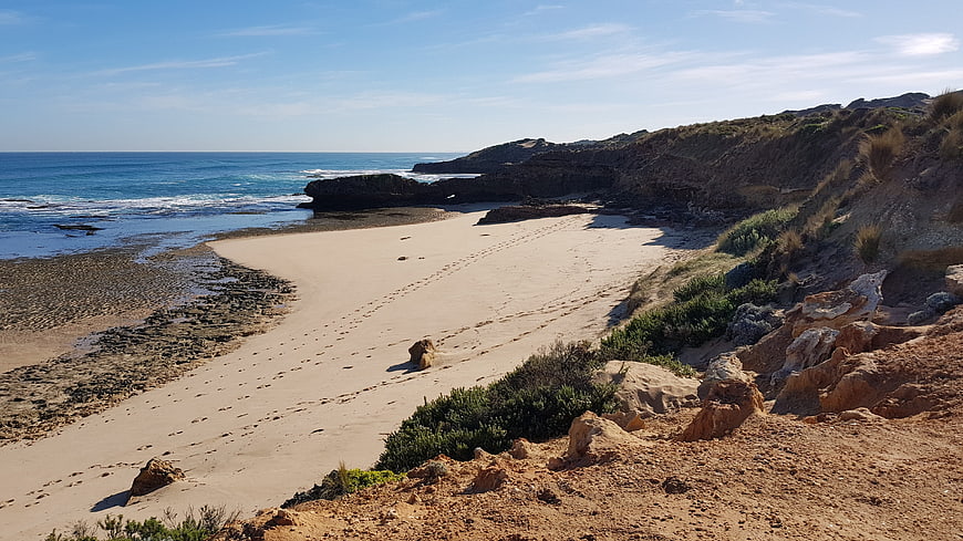 Sandy Beach Cove with Rocky Cliffs and Blue Ocean