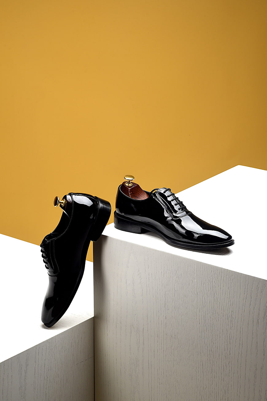 Black Patent Leather Oxford Shoes on White Geometric Blocks