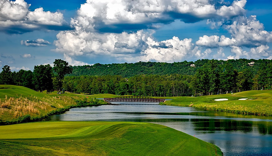 Lush Golf Course Landscape with Bridge and Cloudy Sky