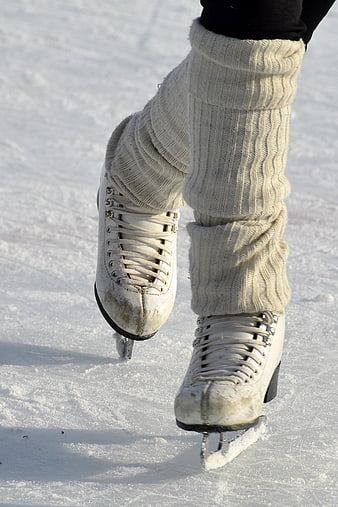Close-up of white ice skates on snowy ice rink