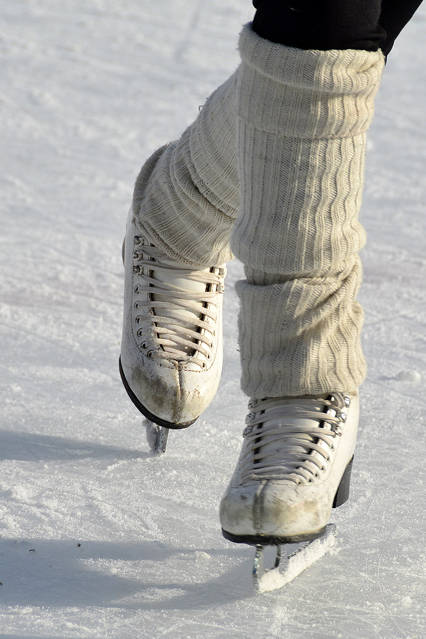 Close-up of white ice skates on snowy ice rink