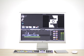 Apple iMac with video editing software on wooden desk