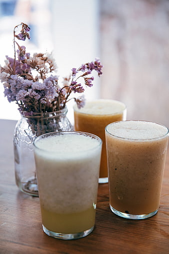 Three Healthy Smoothies with Dried Flowers on Wooden Table