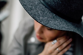 Close-up of woman in gray hat with rings