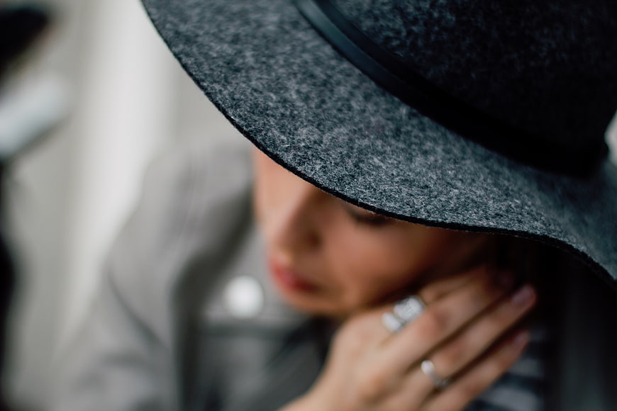 Close-up of woman in gray hat with rings