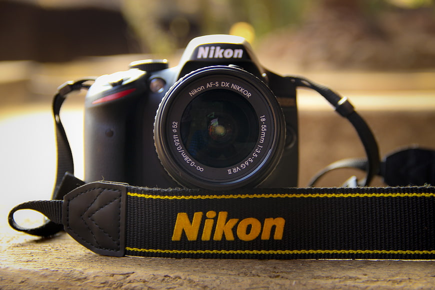 Nikon DSLR Camera with Strap on Wooden Surface