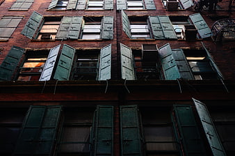 Old brick building facade with green wooden shutters