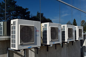 Row of white Fujitsu air conditioning units on concrete wall