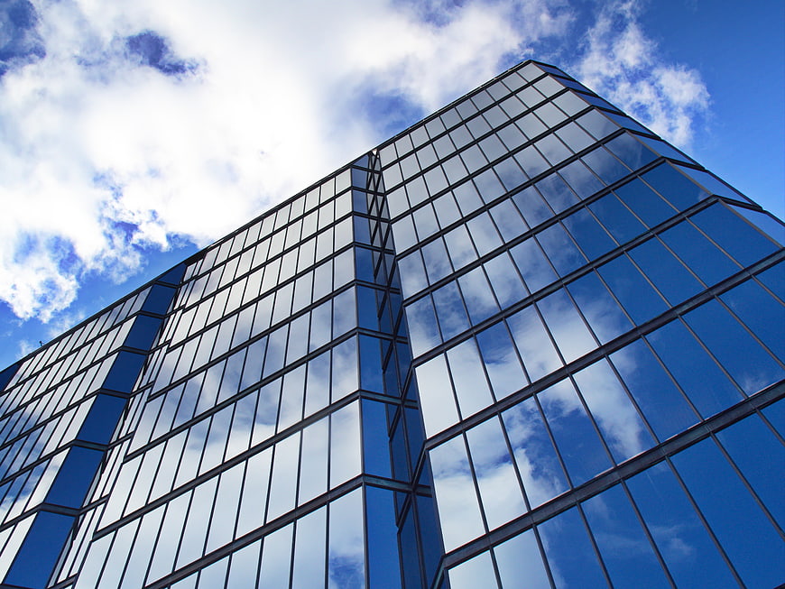 Modern Glass Skyscraper Architecture with Blue Sky Reflection