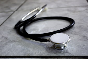 Black stethoscope on gray marble surface