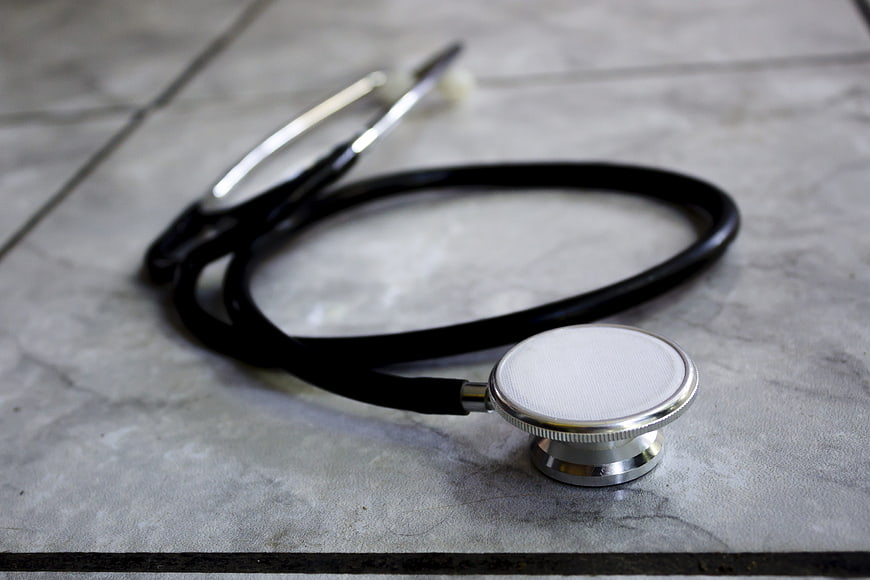Black stethoscope on gray marble surface