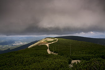 Dramatic Mountain Ridge Path Under Stormy Clouds