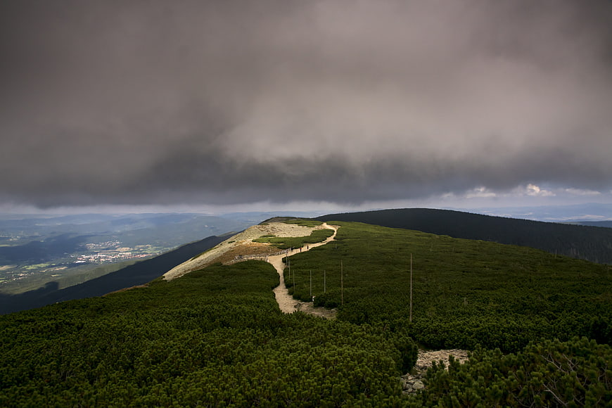 Dramatic Mountain Ridge Path Under Stormy Clouds