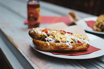 Loaded Beef Hot Dog with Toppings on Wooden Table