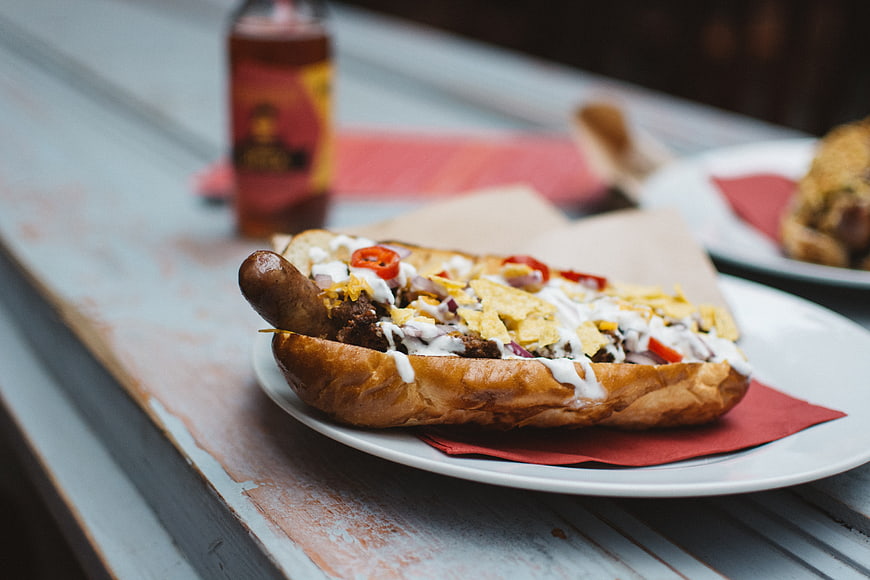 Loaded Beef Hot Dog with Toppings on Wooden Table