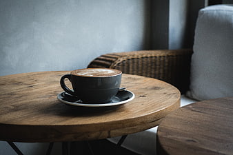 Cappuccino with latte art on rustic wooden table