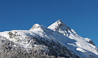 Snow-Covered Mountain Peak Against Clear Blue Sky