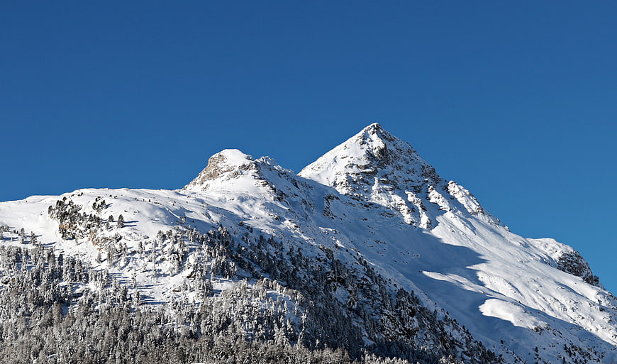 Snow-Covered Mountain Peak Against Clear Blue Sky