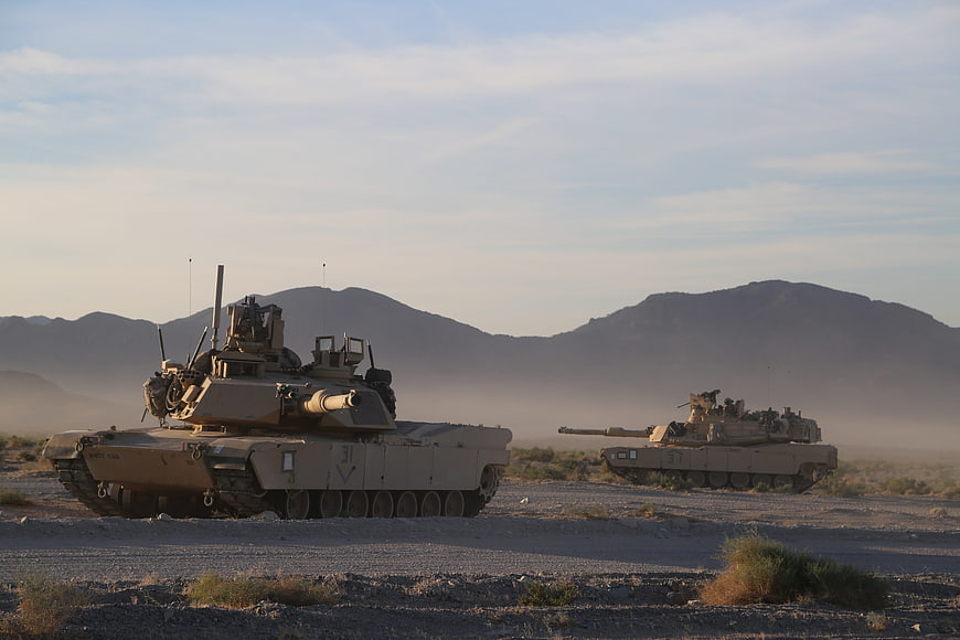 M1A2 Abrams tanks maneuvering in desert landscape