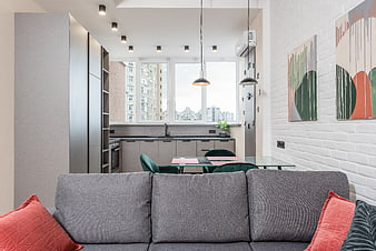 Modern apartment interior with gray sofa and kitchen