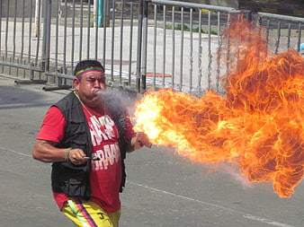 Man Breathing Fire at Outdoor Carnival Event