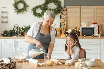 Grandmother and granddaughter baking cookies in a festive kitchen