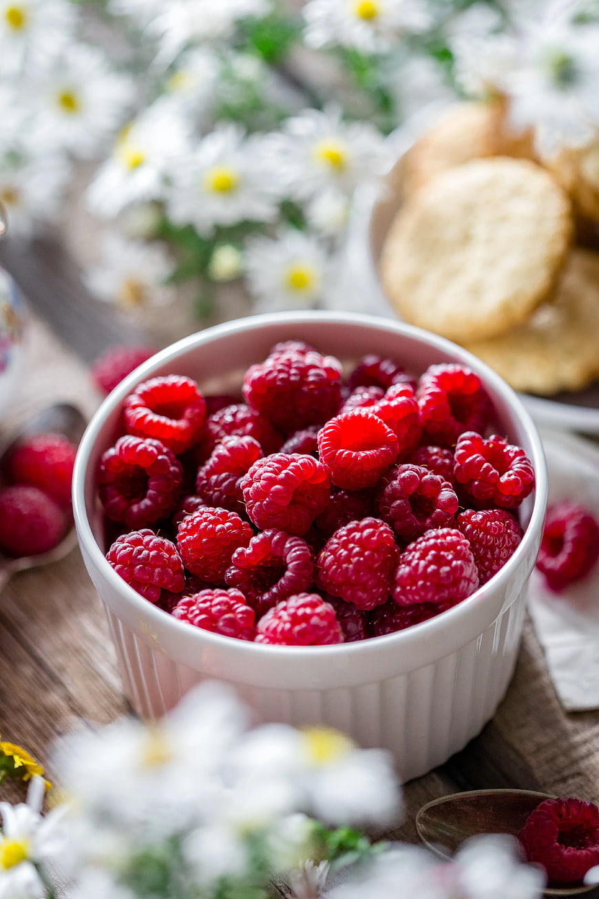 Fresh Raspberries in White Bowl with Daisies