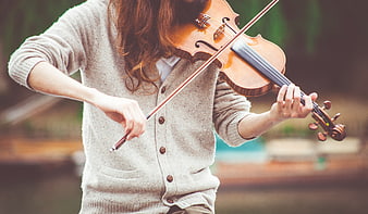 Woman Playing Violin Outdoors in Beige Cardigan