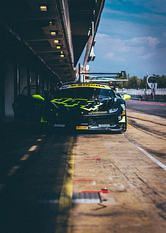 Black Racing Car in Pit Lane with Neon Green Accents