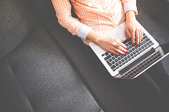 Woman Typing on Laptop on Gray Sofa