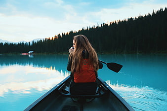 Woman in Canoe on Serene Lake at Sunset