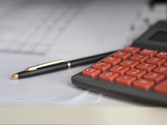 Close-up of calculator and pen on financial documents