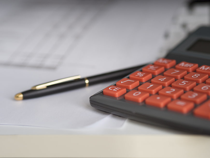 Close-up of calculator and pen on financial documents