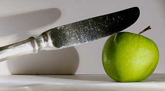 Green Apple and Silver Knife on White Background