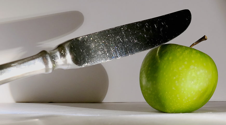 Green Apple and Silver Knife on White Background