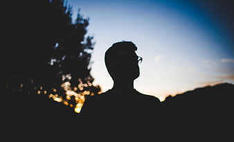 Silhouette of Man Looking Up at Sunset Sky