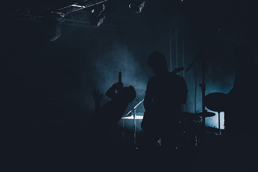 Silhouetted Rock Band Performing Live on Dark Stage