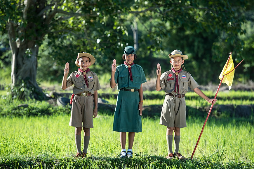 Three Thai Scouts Saluting in Green Field